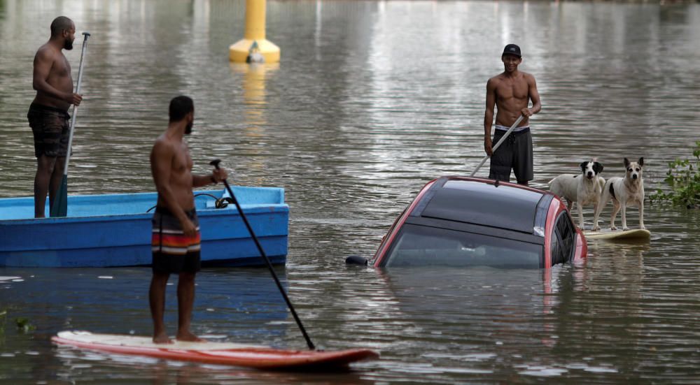 Residents try to rescue a car pushed by the ...