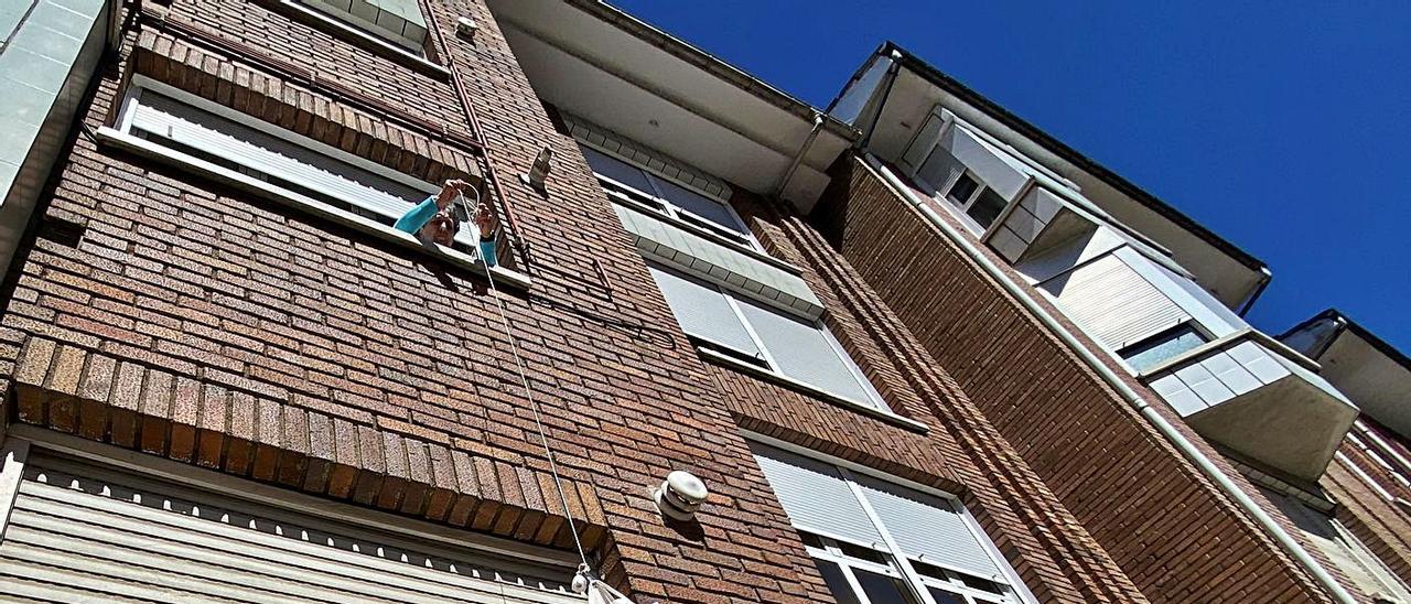 Así recibe una lenense aislada por el covid los libros de la biblioteca: por la ventana y con una cuerda