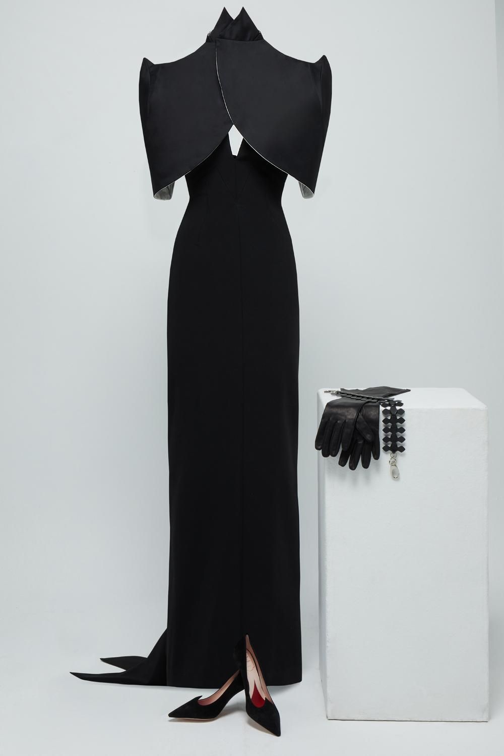 Jenny Beavan para Cruella: Vestido negro con cuello halter y espalda descubierta, y esclavina negra con hombreras más complementos