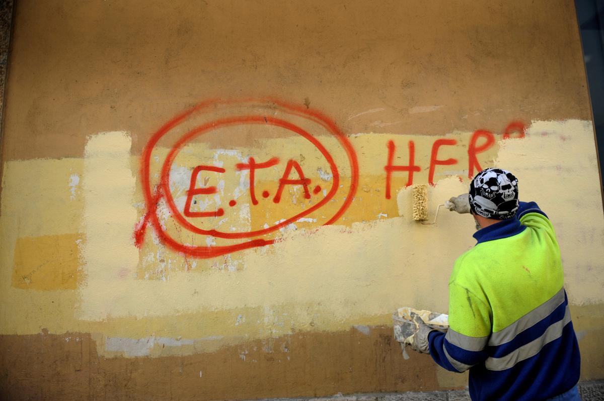 FILE PHOTO: A municipal worker paints over graffiti reading ETA, The People Are With You in Guernica, Spain, October 21, 2011, the day after Basque separatist group ETA announced a definitive cessation of armed activity. REUTERS/Vincent West/File photo