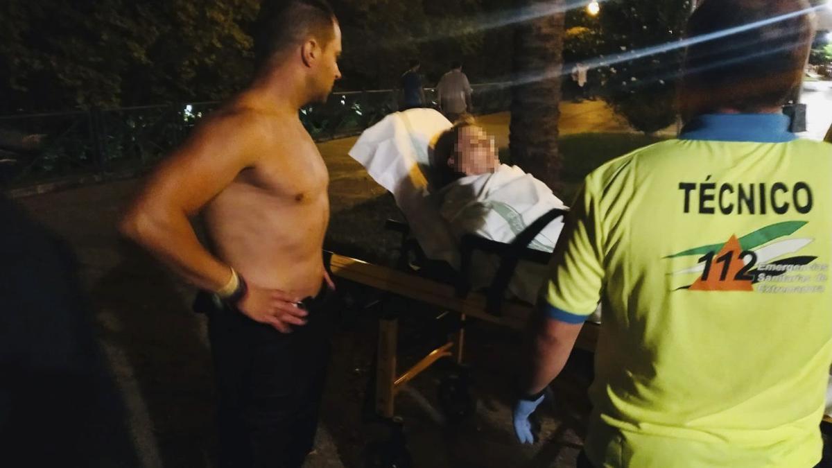 El agente Adilo Molinero junto a la mujer tras ser rescatada del río.