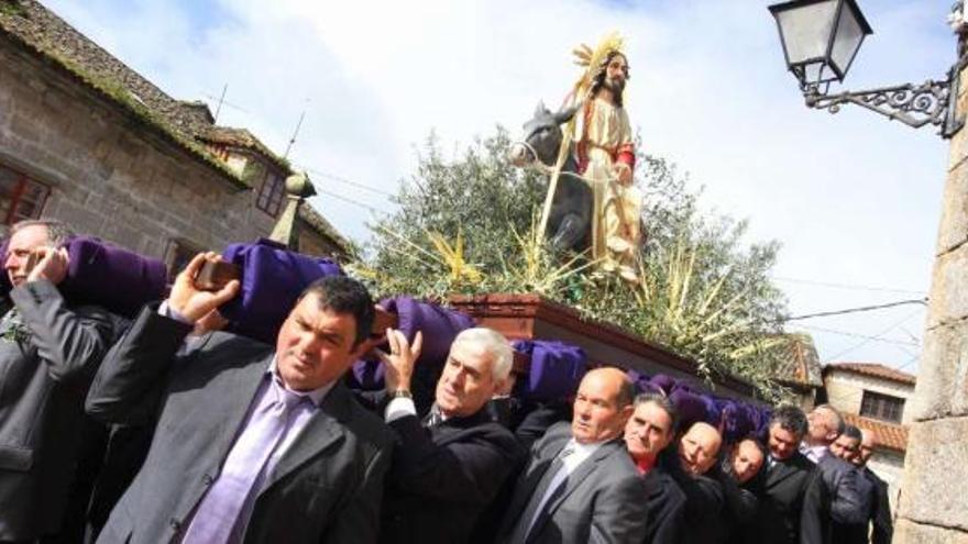 Veintiocho hombres portan la pesada imagen de La Borriquita a la salida de la iglesia de San Benito de Cambados  // J.L.Oubiña