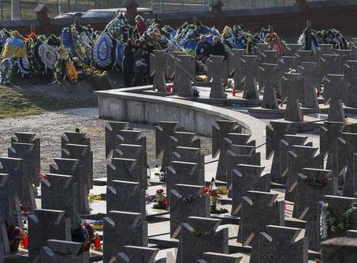 Relatives visit graves of servicemen of Ukrainian military forces, killed in recent fighting in eastern Ukraine, which are located next to a memorial for the World War Two members of Ukrainian Insurgent Army (UPA), in Lviv