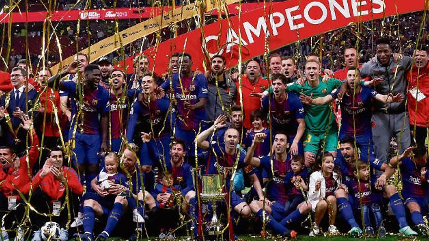 Los jugadores del Barcelona posan en el campo con el trofeo de campeones. // Efe