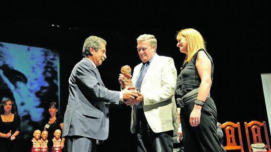 El ex presidente de Cantabria Miguel Ángel Revilla entrega el premio a Carlos Tejo y Patricia Llamedo.