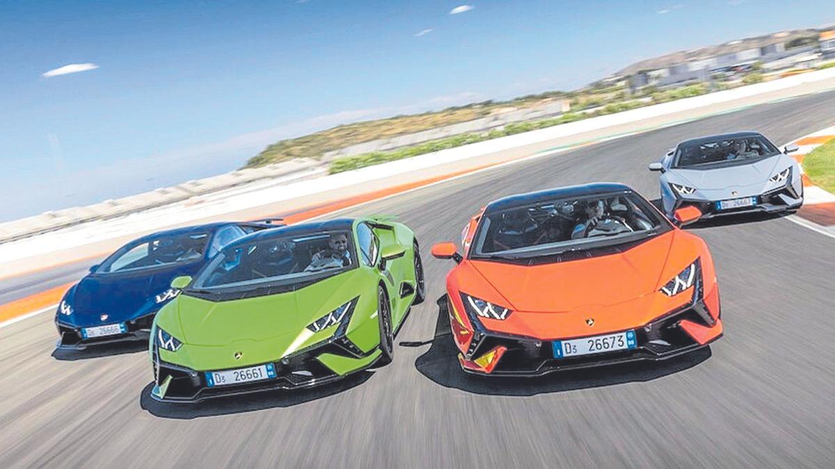Cuatro coches de la marca Lamborghini en un circuito cerrado.