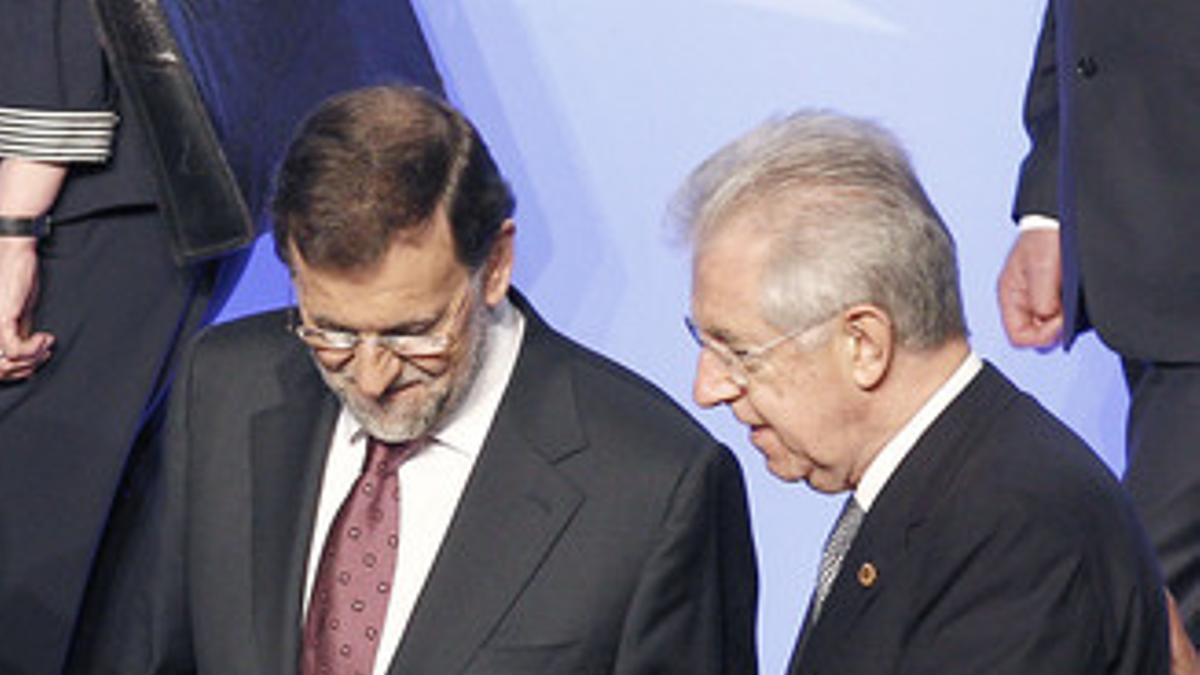 Mariano Rajoy y Mario Monti hablan durante los preparativos para la foto de familia de la cumbre de la Alianza, el domingo en Chicago.