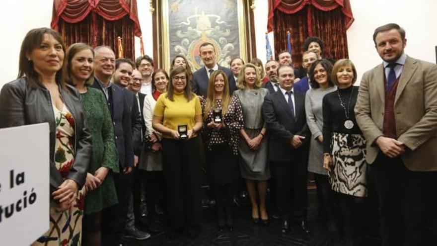 Miembros de la Corporación municipal de Elche con los homenajeados durante la celebración del aniversario de la Constitución Española en el Ayuntamiento.