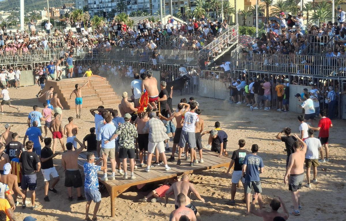 La plaza y la arena, abarrotadas, en el momento en el que una vaquilla cornea a un joven