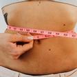 Una mujer midiéndose el abdomen