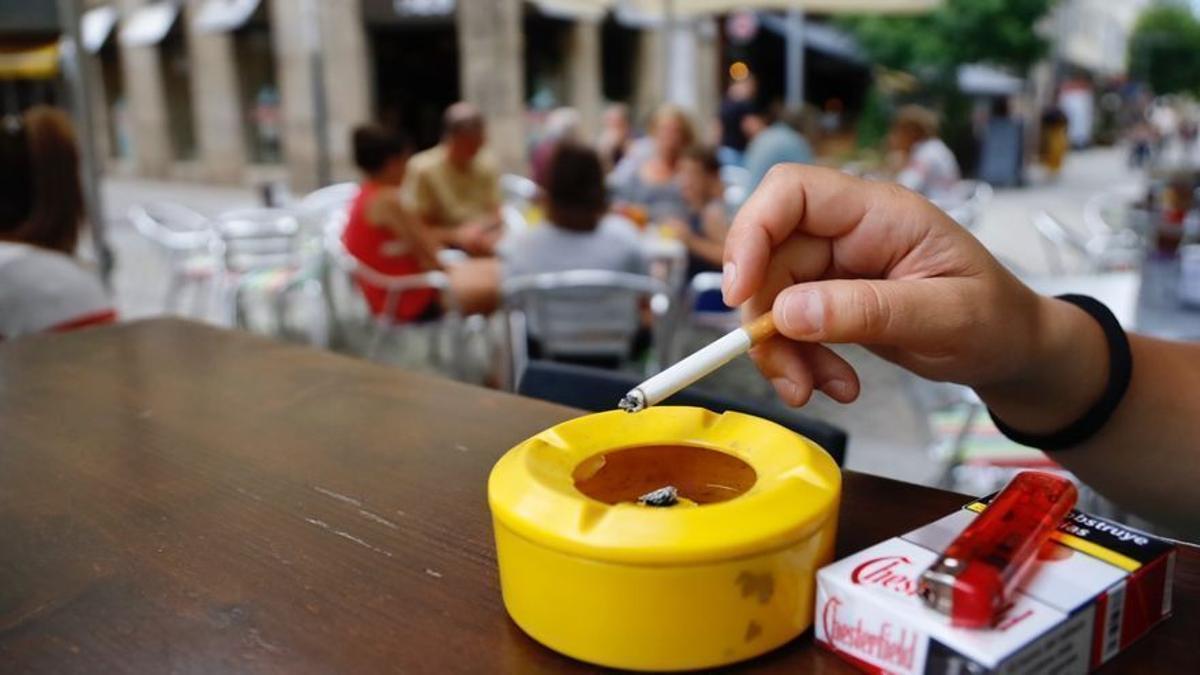 Una persona fumando en una terraza.