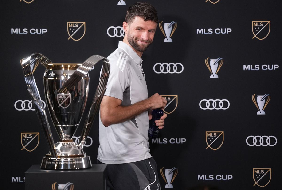 Vancouver Whitecaps' Thomas Muller looks at the MLS Cup trophy as he arrives for a news conference Thursday, Dec. 4, 2025, in Fort Lauderdale, Fla., ahead of Saturday's of the MLS Cup soccer match against Inter Miami. (Darryl Dyck/The Canadian Press via