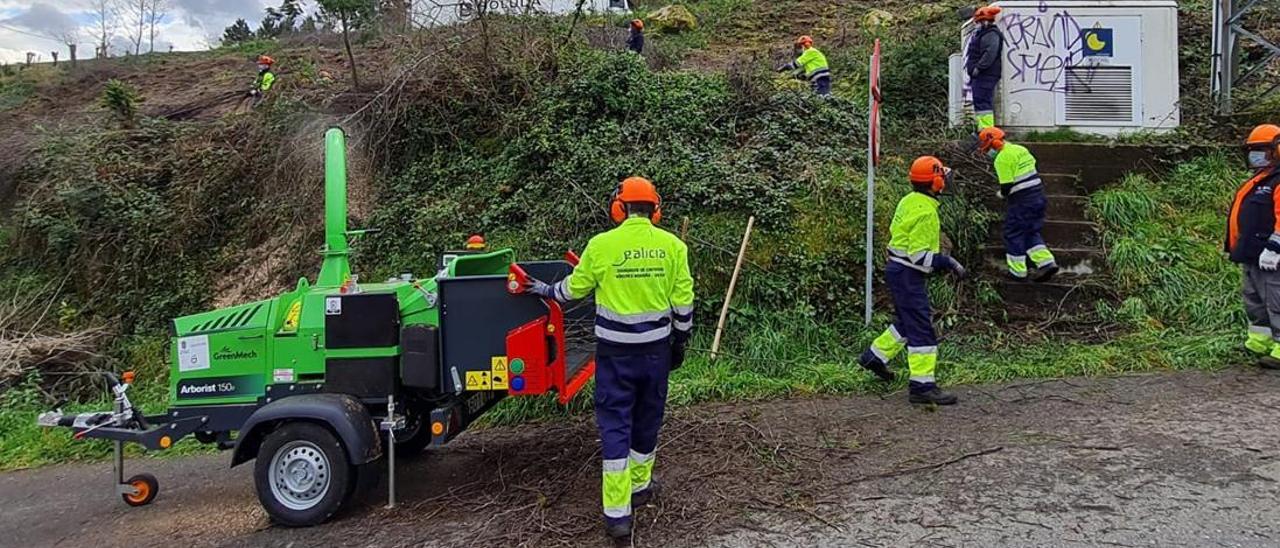 Los alumnos del &quot;obradoiro&quot;, trabajando en Beiro con la máquina trituradora.