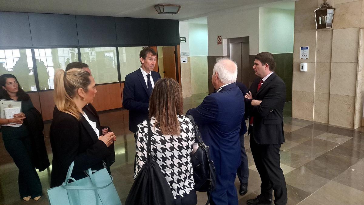 Los abogados charlan con el fiscal, Diego Yebra, en el vestíbulo de la Audiencia Provincial de Badajoz, este martes.