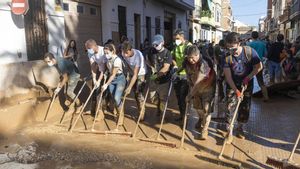 Vecinos y voluntarios de Paiporta retiran el lodo acumulado en una de las calles.