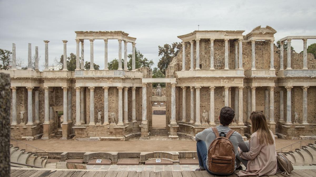 Dos turistas contemplan el teatro romano de Mérida.