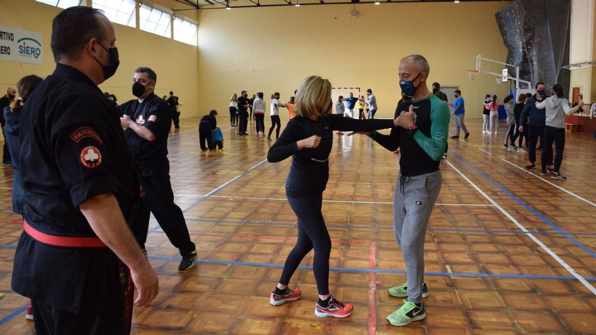 El maestro Jesús Cofiño, a la izquierda, observa la práctica de Gemma García y Jesús Abad, en el polideportivo poleso.  | A. S.