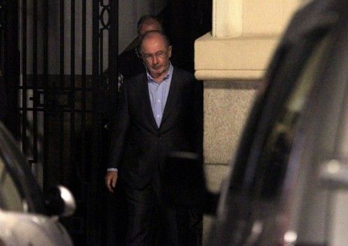 El exvicepresidente del Gobierno Rodrigo Rato (d) abandona su despacho cuatro horas después de que comenzara el registro por parte de los agentes de la Agencia Tributaria y de Aduanas, que han sacado una veintena de cajas con documentación.