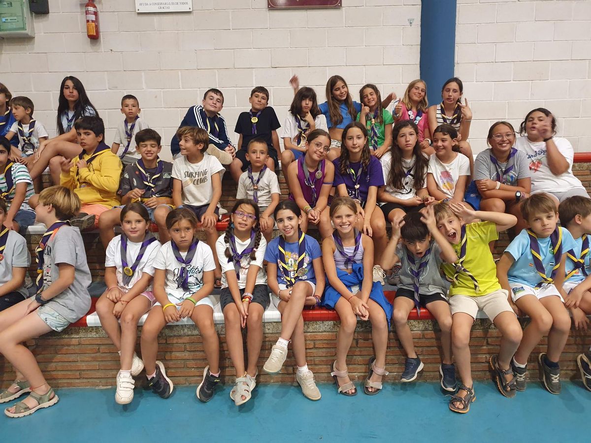 Los niños sentados en las gradas del polideportivo.