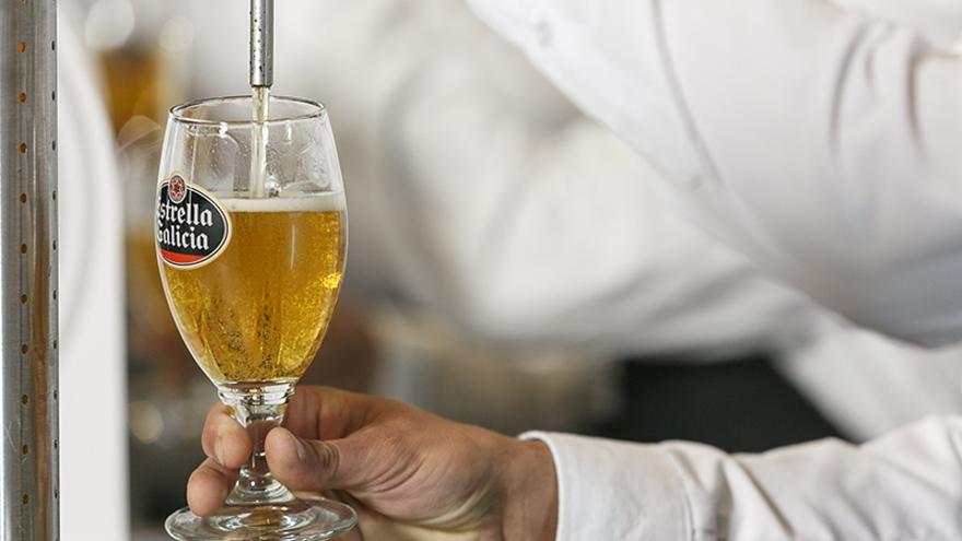 Un profesional sirve una caña de cerveza Estrella Galicia.
