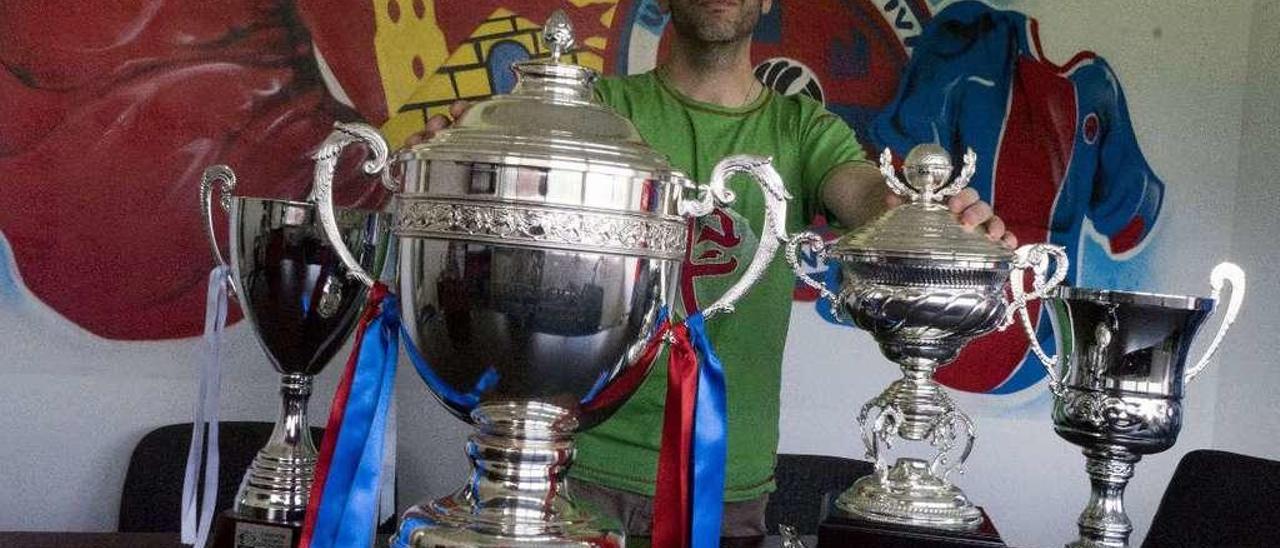 Modesto García, el presidente de la Unión Deportiva Ourense, posa con las copas de los cuatro ascensos, ayer en O Couto. // Enzo Sarmiento