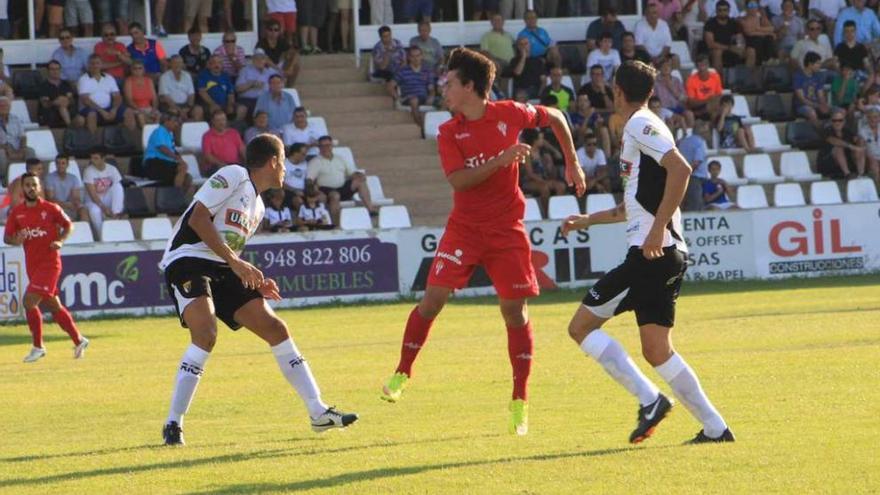 Jaime toca el balón de cabeza ante dos jugadores del Tudelano.