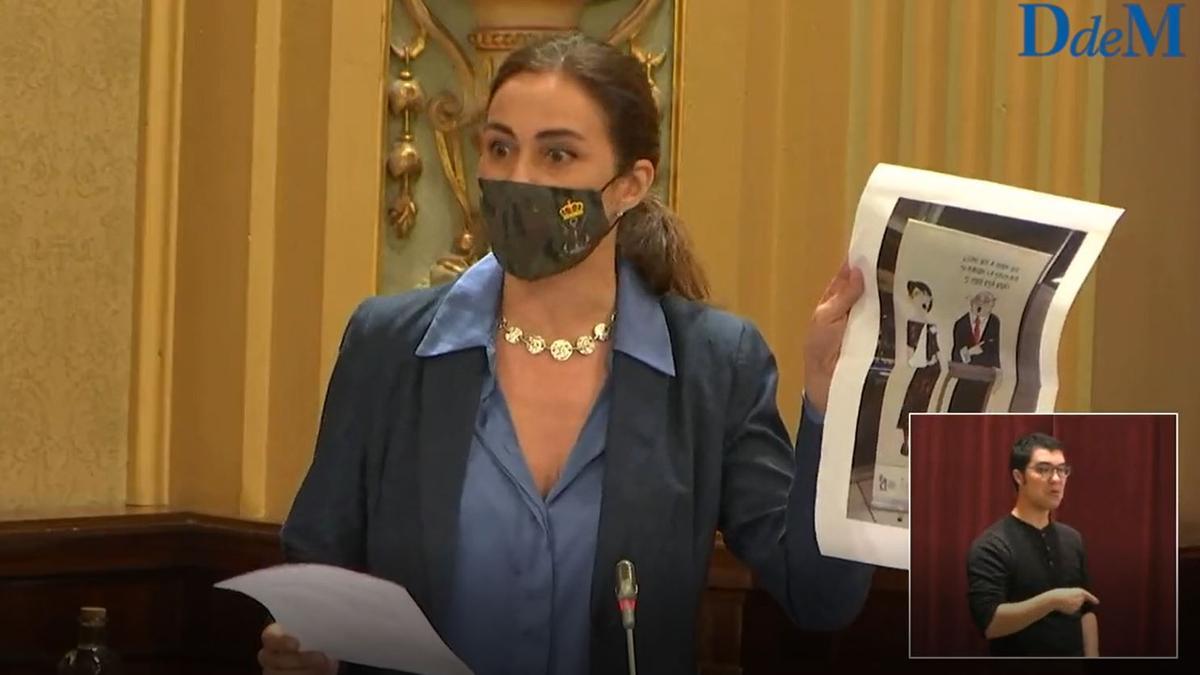 La diputada de Vox Idoia Ribas muestra en el Parlament la viñeta de la exposición ahora retirada por protestas de magistrados de Palma