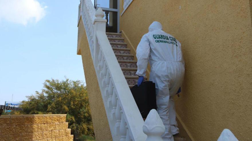 Un agente de la Guardia Civil inspecciona el piso donde ha aparecido la víctima.