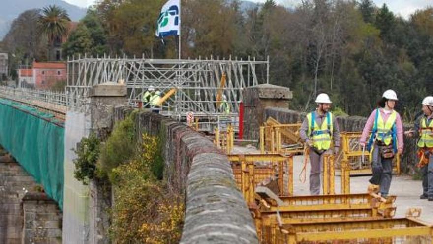 Unos trabajadores en uno de los extremos del viaducto antiguo de Redondela, donde se instala un andamio, ayer.  // Faro