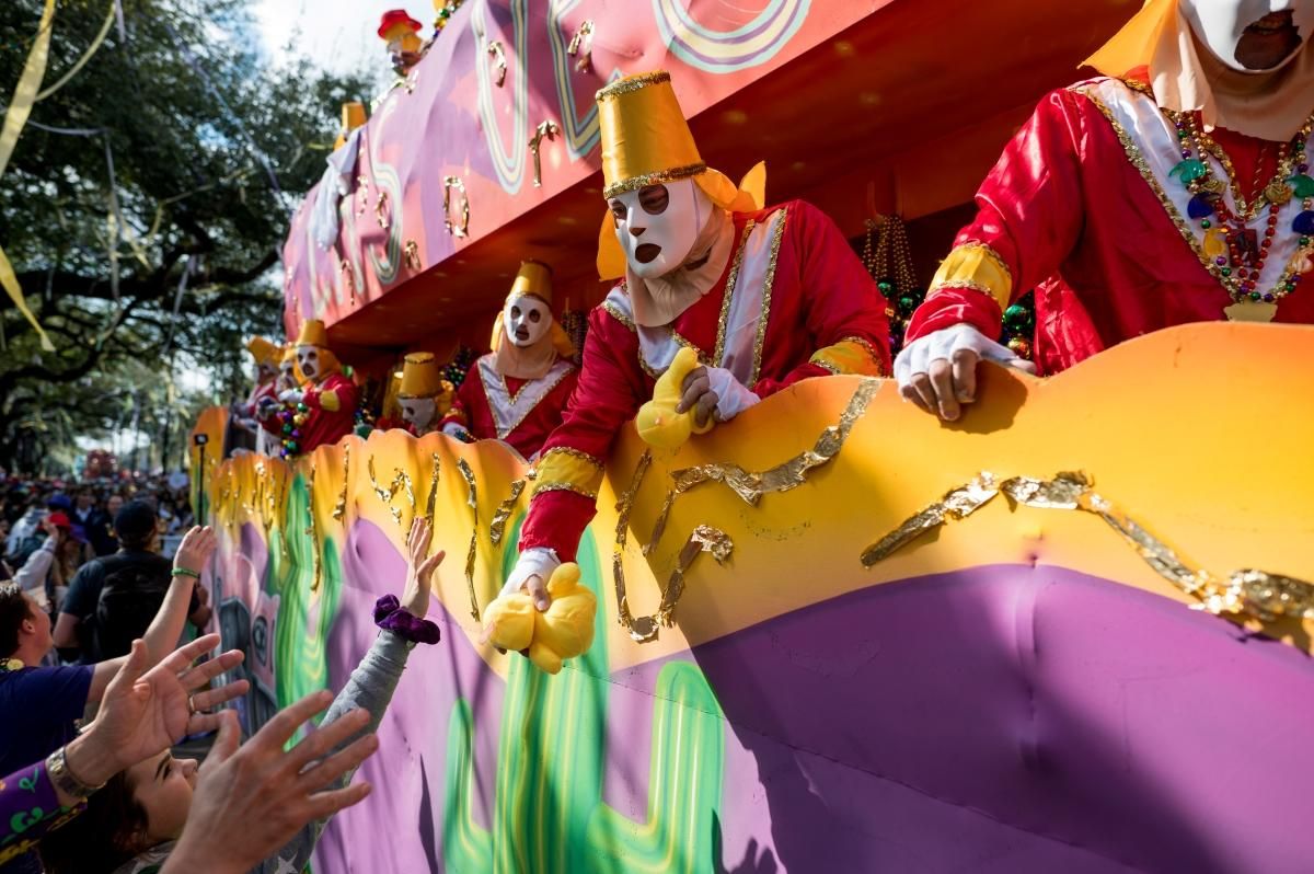 Un krewe distribuyendo regalos desde su carroza en Mardi Gras.