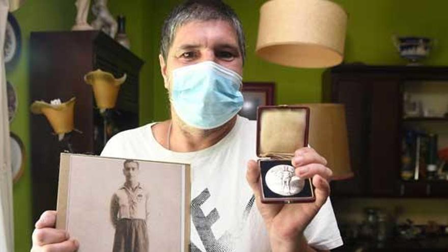 Alejandro González, nieto de Ramón, posa con la medalla de plata y con una foto de su abuelo.