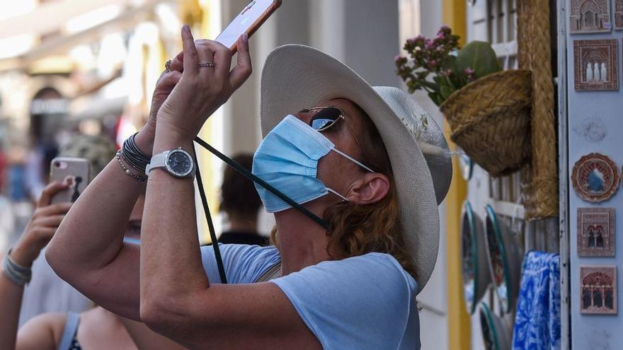 Dos turistas realizan fotografías en una calle de la Judería