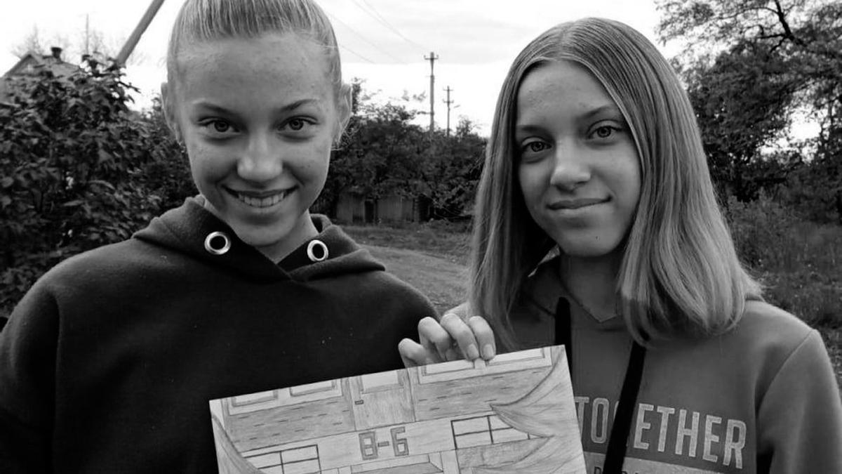 Yuliya y a Anna compartiendo un dibujo hecho a mano para conmemorar el 60 aniversario de la construcción de su escuela