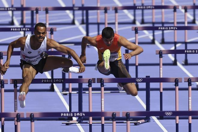  El atleta español Asier Martínez (d) compite en la segunda serie de los 110m valla masculinos en los Juegos Olímpicos de París 2024 en el Estadio de Francia, este domingo, en la capital gala. 