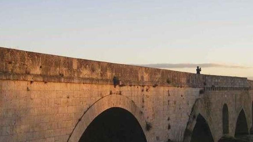 Vecinos toman fotografías desde el puente de piedra en una de las últimas crecidas del Duero.