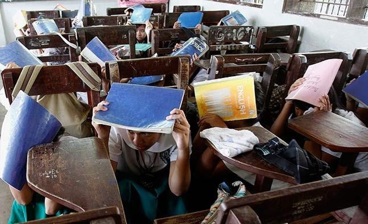 Uns estudiants filipins es cobreixen el cap amb els seus llibres de text durant un simulacre de terratrèmol a Manila. Centenars d’estudiants de les escoles públiques de Filipines van participar en aquest simulacre simultani de terratrèmol.