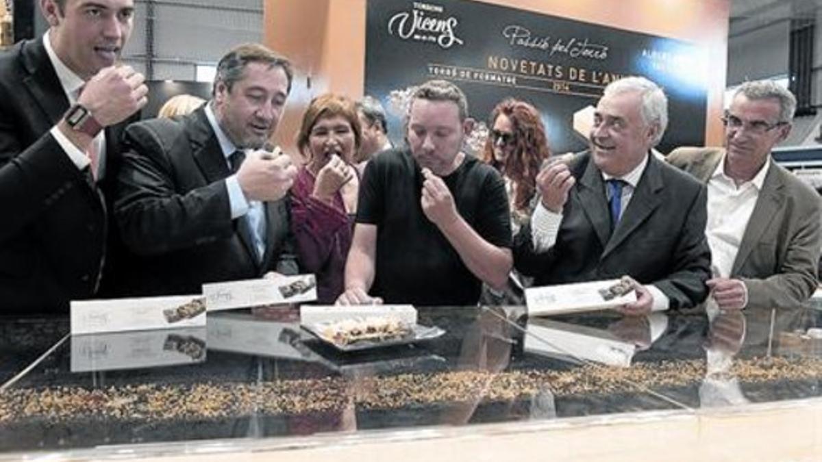 CATA INAUGURAL. El 'conseller' de Agricultura, Josep María Pelegrí, pueba el nuevo turrón junto a Albert Adrià (en el centro).