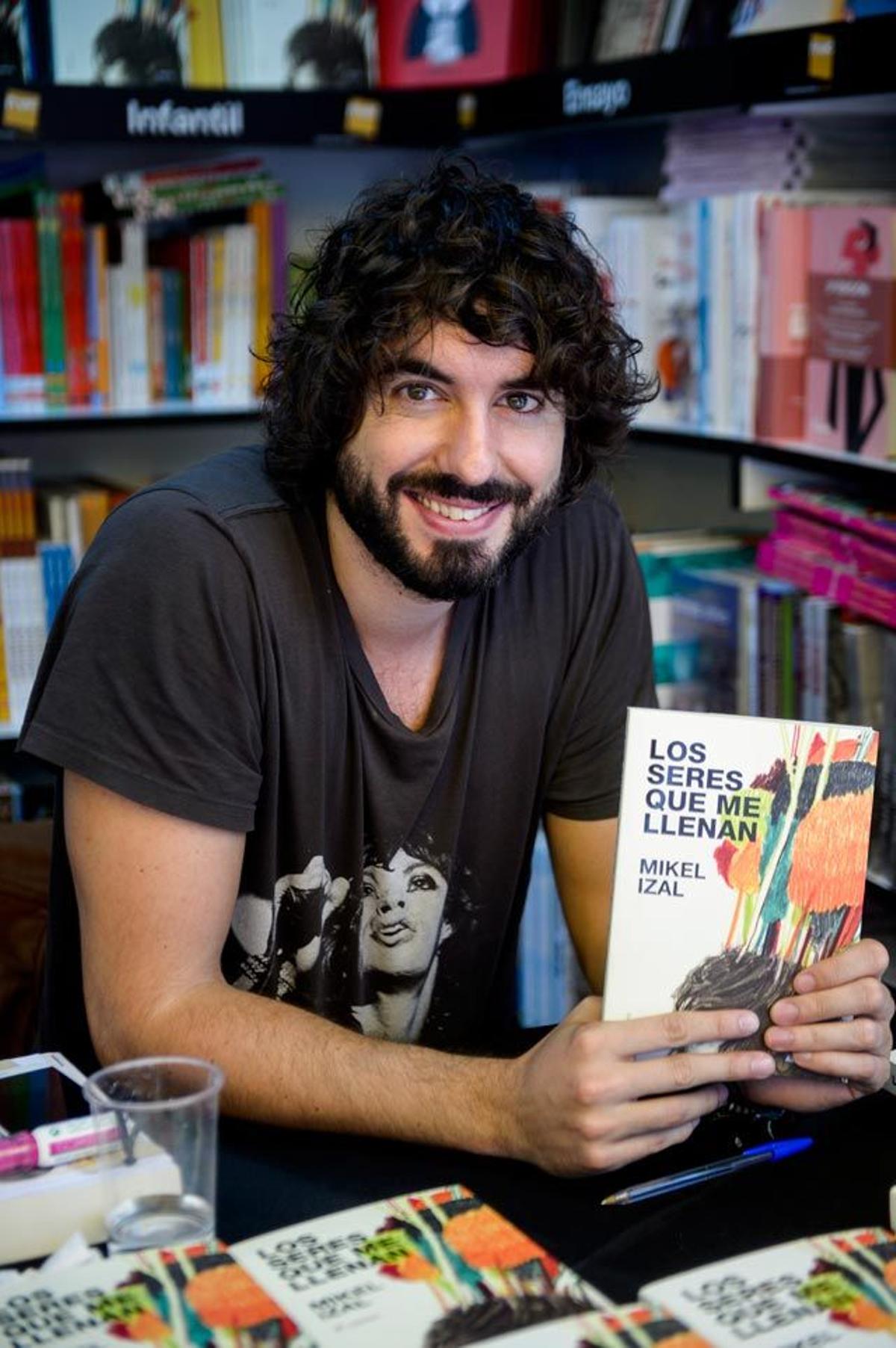 El cantante Mikel Izal posa sonriente junto a su libro Los seres que me llenan en la Feria del Libro de Madrid.
