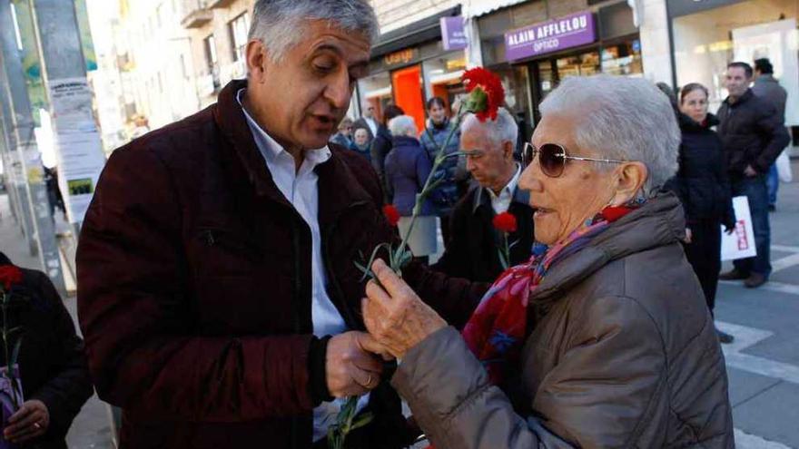 José Luis Gómez entrega un clavel a una ciudadana.