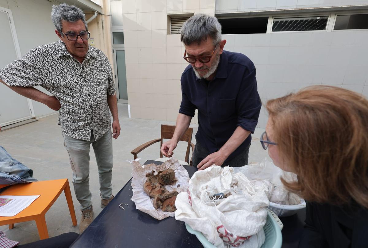 Rafael Tormo, en el centro, muestra una de las piezas de arcilla a los participantes en el taller.
