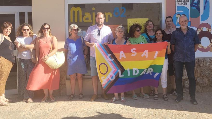 Vecinos y vecinas y organizadores del acto posan con una bandera con los colores del colectivo LGTBI, este martes en Pòrtol.