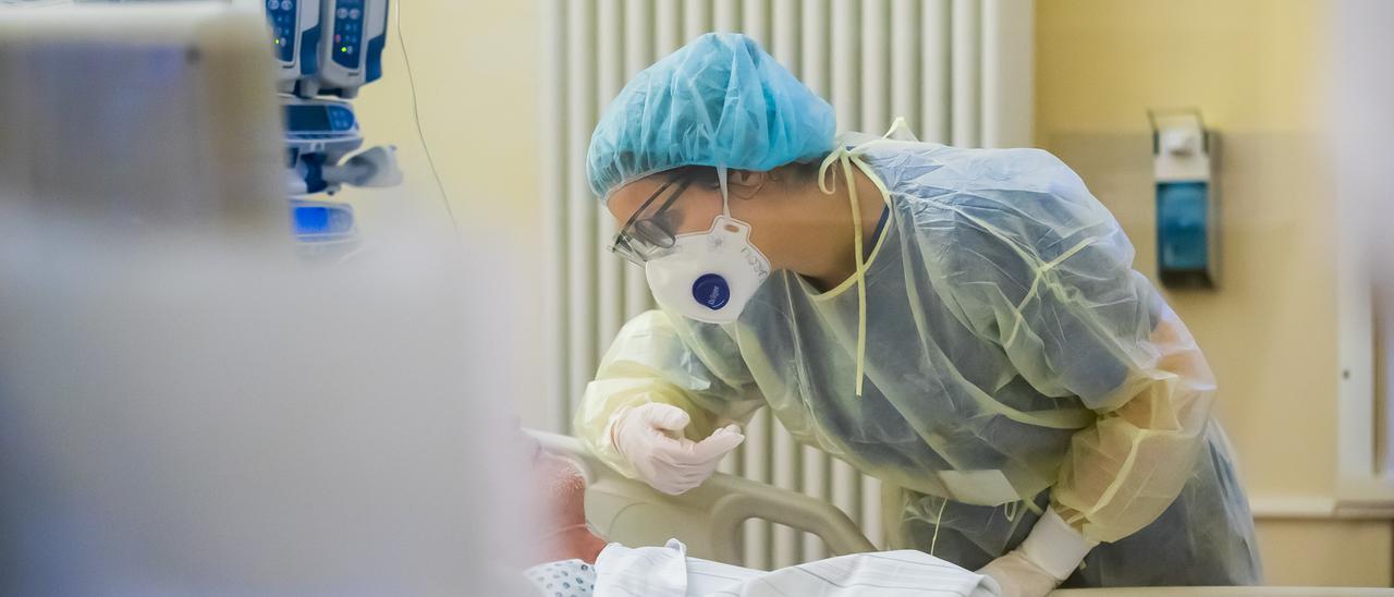 Una sanitaria atiende a un paciente con coronavirus.