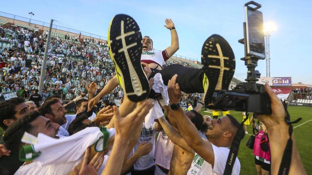 Los jugadores mantean a Crespo tras el ascenso en Mérida a Primera Federación.