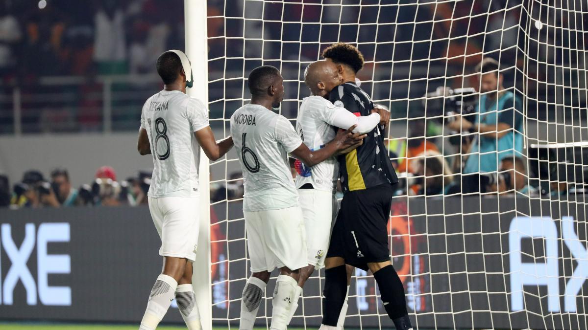 Los futbolistas sudafricanos abrazan a su portero, Ronwen Williams, tras el fallo de Achraf desde los once metros