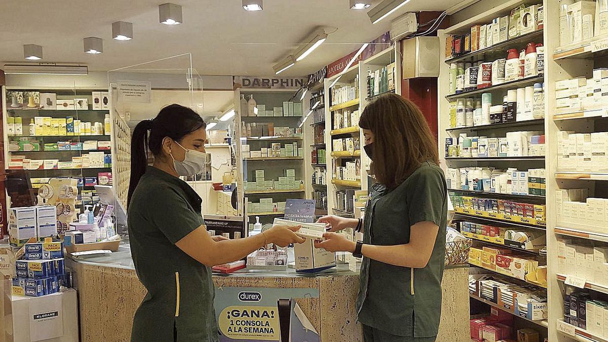 Imane Tahriyne i Raquel Miralles, de la farmàcia Planas de Manresa, mostrant els tests d’antígens | L.S.