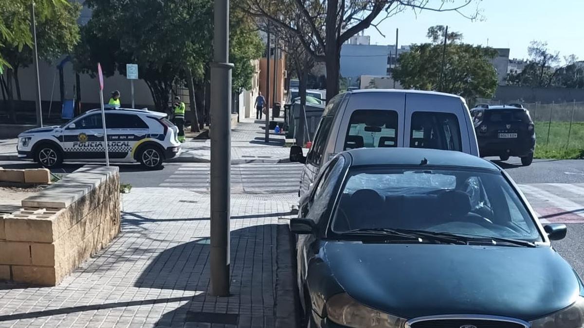 Los operarios de limpieza en las calles de la Magdalena con un coche patrulla.