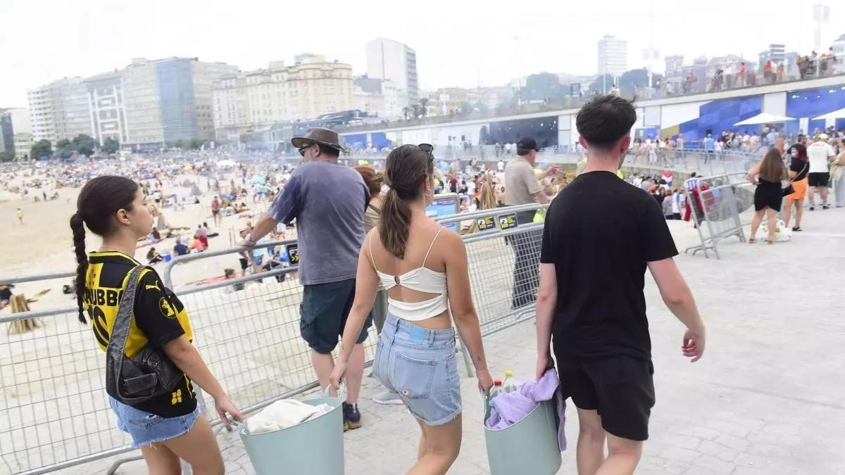 Unos jóvenes caminan por las inmediaciones de la playa de Riazor en San Juan