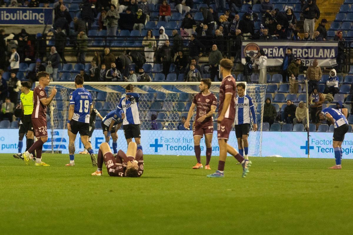 Guti, en el centro, entre jugadores extenuados al final del Hércules-Antequqera.