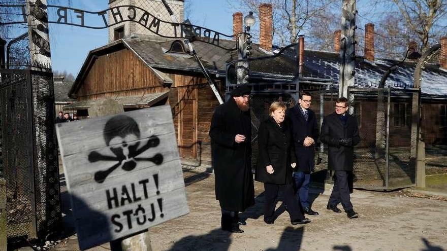 Angela Merkel, arriba, a la entrada de Auschwitz. Abajo, durante su alocución.