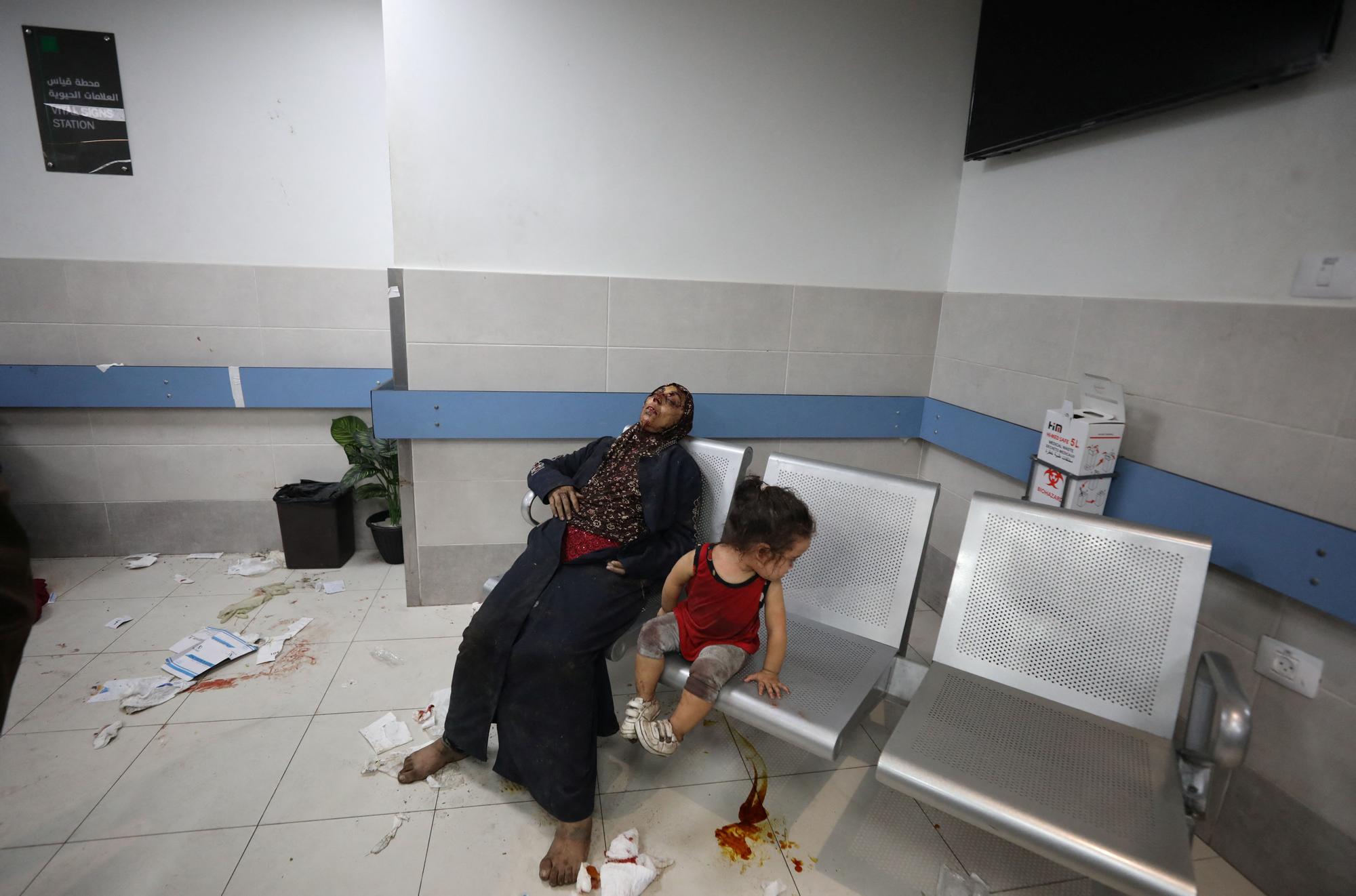 Injured people are assisted after Israeli air strike hit a hospital, according to Gaza Health Ministry